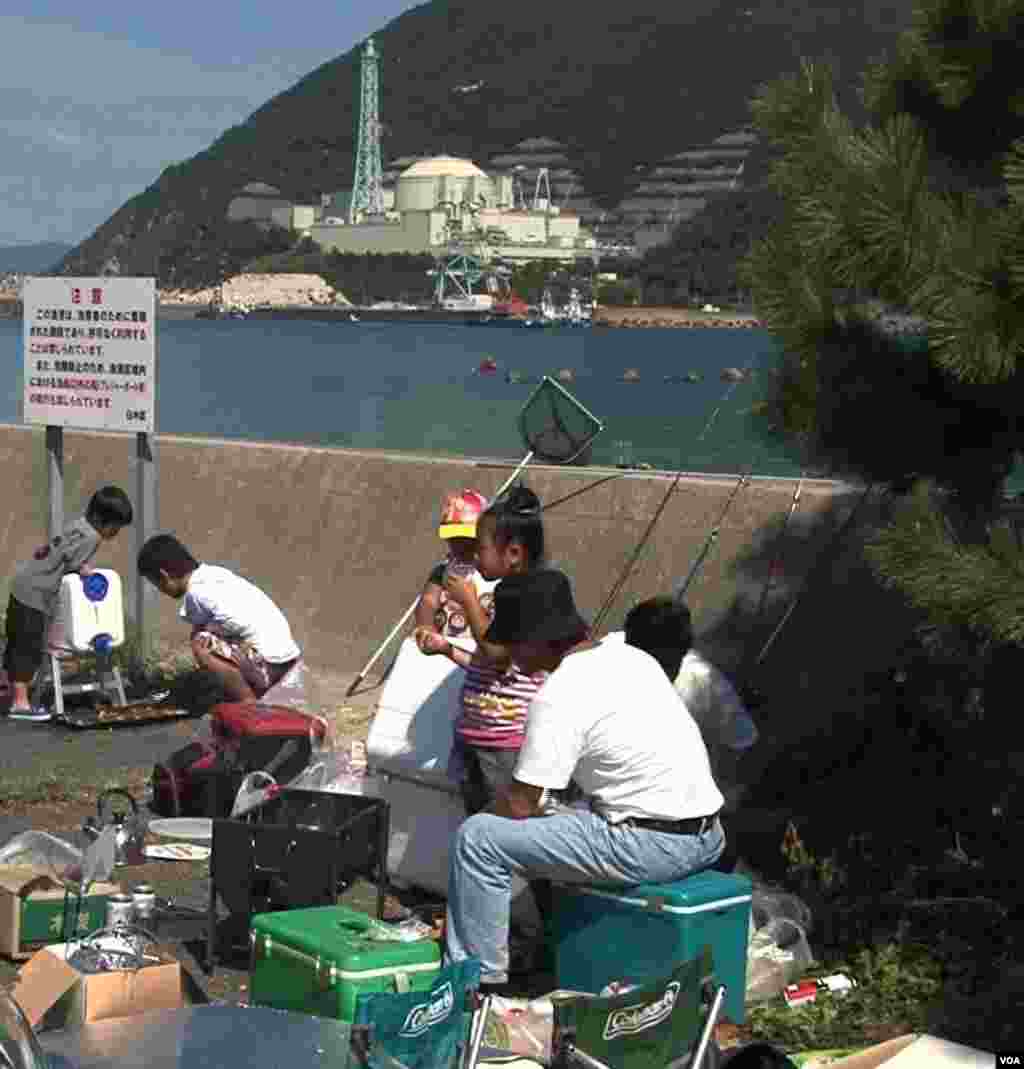 A family picnics across the bay from the Monju nuclear reactor facility in Fukui Prefecture, Japan, Sep. 25, 2012. (S. Herman/VOA)