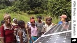 Des villageois dans le District de Kalale scrutant un panneau solaire nouvellement installé. 