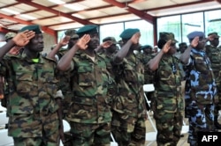 FILE – Members of the Uganda People’s Defense Forces (UPDF) salute after completing a nine-week course led by Marines of the Special Purpose Marine Air-Ground Task Force (SPMAGTF) at a training center in Singo, Sept. 28, 2013.