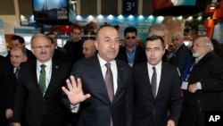 Министр иностранных дел Турции Мевлют Чавушоглу (в центре) на туристической ярмарке в Берлине. 8 марта 2017 года.