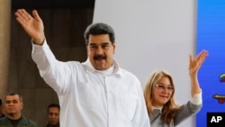 Venezuela's President Nicolas Maduro, left, and his wife Cilia Flores greet supporters upon their arrival to a meeting with Colombian citizens that reside in Venezuela, In Caracas, Venezuela, Tuesday, Sept. 25, 2018. 