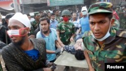 26일 방글라데시 건물 붕괴 현장의 돌무더기에서 발견한 부상자를 병원으로 이송하는 구조대.