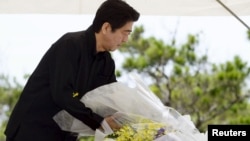 Yaponiya Bosh vaziri Shinzo Abe Okinava orolida urush qurbonlari xotirasi uchun qurilgan yodgorlikka gulchambar qo'ymoqda, 23-iyun, 2015-yil.