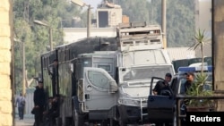 Egyptian police escorts stand by vehicles for general prisoner transport at Tora prison, Cairo, August 22, 2013.