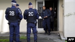 Anti-riot policemen stand outisde an appartment building, where suspects are being arrested by the police during an operation to dismantle a drug trafficking and clandestine immigration network in Mulhouse, eastern France, October 16, 2012. 