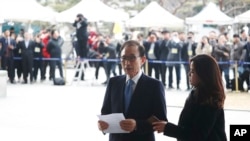 FILE - Former South Korean President Lee Myung-bak speaks upon arrival for questioning over bribery allegations at the Seoul Central District Prosecutors' Office in Seoul, South Korea, March 14, 2018. 