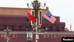 ILUSTRASI - Bendera Malaysia berkibar di sebelah bendera China (kiri) di Lapangan Tiananmen, saat kunjungan Perdana Menteri Mahathir Mohammad di Beijing, China, 19 Agustus 2018. (Foto: Stringer/Reuters)