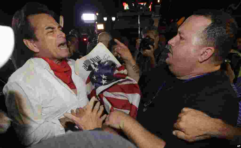 Demonstran anti-Castro Sisay Barcia (kanan), beradu mulut dengan pendukung pro-Obama Peter Bell di Little Havana di Miami (17/12). (AP/Alan Diaz)