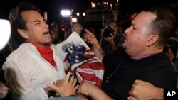 Anti-Castro protester Sisay Barcia, right, argues with pro-Obama supporter Peter Bell, left, in the Little Havana area of Miami, Wednesday, Dec. 17, 2014. (AP Photo/Alan Diaz)