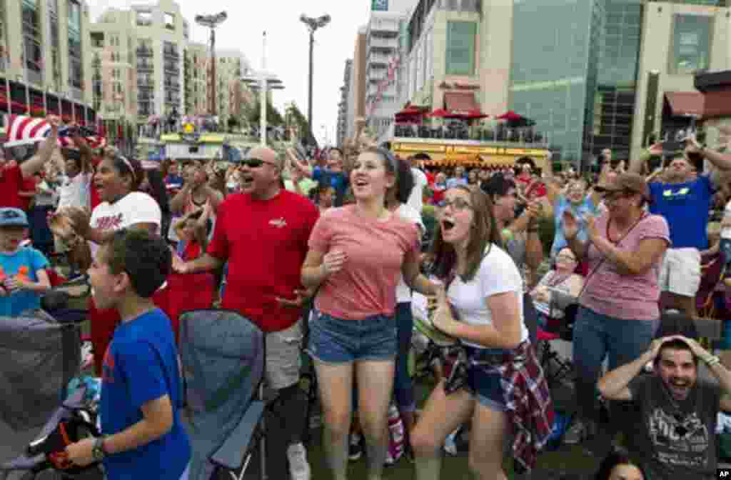 Para penggemar yang menonton pertandingan dari layar di udara terbuka di National Harbor, Maryland, AS, bersorak merayakan gol ketiga melawan Jepang dalam Piala Dunia Putri di Vancouver, Kanada (5/7). (AP/Jose Luis Magana)