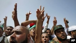 People flash victory signs as they gather at Martyrs Square after Friday prayers in Tripoli, September 2, 2011