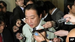 Japanese Finance Minister Yoshihiko Noda (C) speaks to reporters announcing that finance ministers from the G7 group of top economies and central bankers will hold teleconference talks, at his office in Tokyo on March 17, 2011.