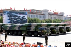 FILE - Military vehicles carry DF-26 medium-range ballistic missiles during a parade commemorating the 70th anniversary of Japan's surrender during World War II held in front of Tiananmen Gate in Beijing, Sept. 3, 2015.