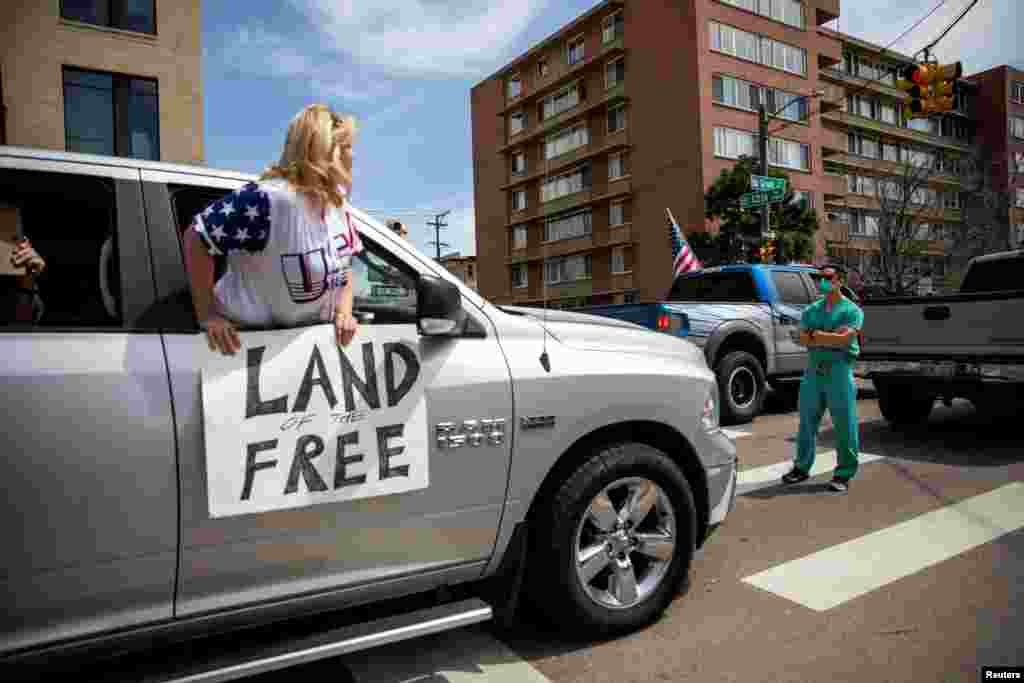 Health care workers stand in the street in counter-protest to hundreds of people who gathered at the State Capitol to demand the stay-at-home order be lifted in Denver, Colorado, April 19, 2020.