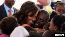 U.S.first lady Michelle Obama hugs students at Martin Luther King middle school, an all-girls school in Dakar, Senegal, June 27 2013. 