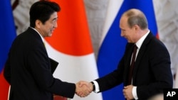 Russia's President Vladimir Putin (R) shakes hands with Japan's Prime Minister Shinzo Abe during a signing ceremony at the Kremlin in Moscow, April 29, 2013.