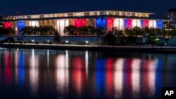 Luces rojas, blancas y azules que marcan el centenario del nacimiento del presidente John F. Kennedy, en el Kennedy Center se reflejan en las aguas del río Potomac, en Washington, el 26 de mayo de 2017.