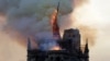 The steeple and spire of the landmark Notre-Dame Cathedral collapses as the cathedral is engulfed in flames in central Paris on April 15, 2019.