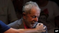 Brazil's former President Luiz Inacio Lula da Silva is embraced during his presidential campaign rally with members of his Workers Party and leaders of other left-wing parties in Rio de Janeiro, April 2, 2018.