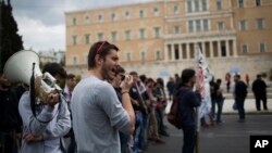 FILE - Protesters chant anti-austerity slogans in front of the Greek Parliament in central Athens, May 6, 2016. 