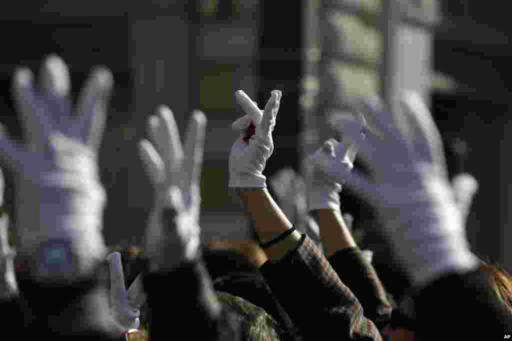 Deaf protesters wearing white gloves raise up their hands during an anti-government rally in central Athens. Organizations representing the disabled and people with chronic diseases traveled from across Greece to join the rally against austerity measures linked to the country&#39;s international bailout.