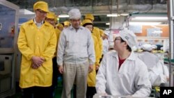 In this March 28, 2012 photo provided by Apple, Inc., Apple CEO Tim Cook, left, visits the iPhone production line at the newly-built manufacturing facility Foxconn Zhengzhou Technology Park, which employs 120,000 people. 