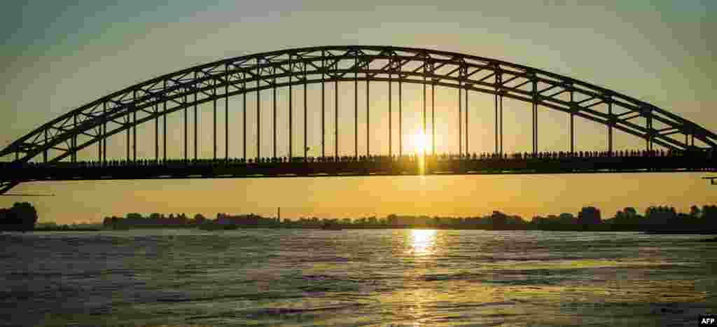 Para peserta melewati jembatan sungai Waal pada hari pertama peringatan tahunan 4 hari &#39;reli Nijmegen&#39; yang ke-100 tahun di Belanda.