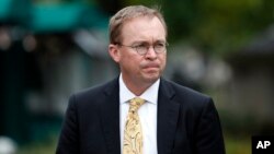 FILE - Mick Mulvaney departs after a television interview at the White House, Sept. 13, 2017, in Washington.