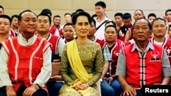 FILE - Myanmar's Foreign Minister Aung San Suu Kyi sits with members of the United Wa State Army (UWSA) following a meeting of armed ethnic groups in Naypyitaw, Myanmar, July 29, 2016.
