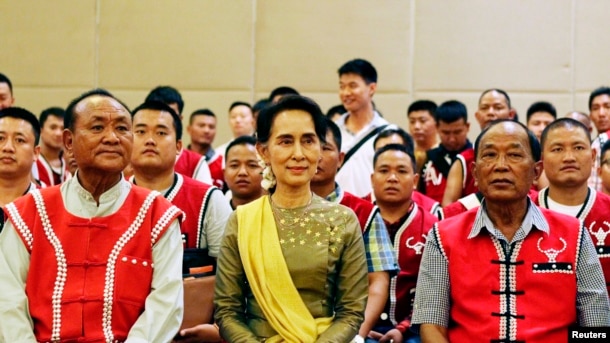 FILE - Myanmar's Foreign Minister Aung San Suu Kyi sits with members of the United Wa State Army (UWSA) following a meeting of armed ethnic groups in Naypyitaw, Myanmar, July 29, 2016.