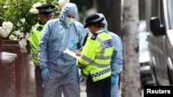 A police officer speaks to forensic investigators outside a property which was raided by police in East Ham, east London, Britain, June 5, 2017.