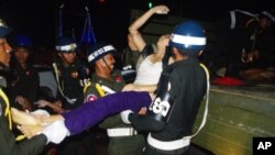 A female victim of the deadly stampede, on Monday November 22, 2010, is carried onto a rescue truck, by Phnom Penh police. Hou Chanthy, 47, lost her daughter, said, "I'm thankful for the donations, but the donations will never compensate me.”