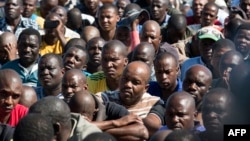 Striking miners gather gathered at the Wonderkop Stadium in Marikana as they wait for Association of Mine workers and construction Union's president Joseph Mathunjwa to address them on May 14, 2014 in Marikana, South Africa.