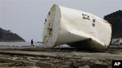 A man walks along the beach in the devastated city of Onagawa, Miyagi prefecture, northeastern Japan, March 25, 2011