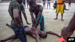 Les membres de l'Unité nationale de sauvetage aquatique du Ghana (GNARU) pratiquent le massage cardiaque lors d’une formation de sauvetage et de premiers secours à Labadi Beach, à Accra, le 22 mars 2018.