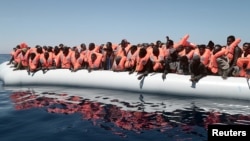 FILE - A plastic raft overcrowded with migrants drifts in the central Mediterranean Sea, May 18, 2017. More than 2,000 migrants were rescued overnight Friday.