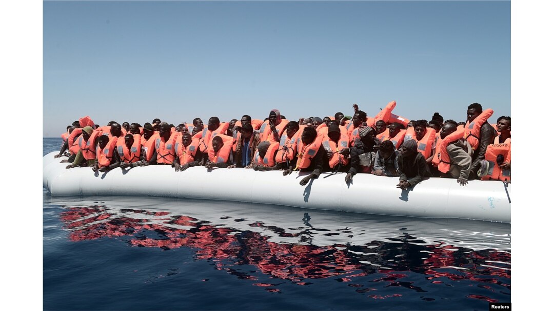 A plastic raft overcrowded with migrants drifts in the central Mediterranean Sea, May 18, 2017.