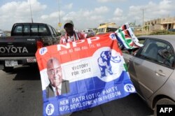 FILE - A vendor hawks flags of the ruling National Democratic Congress and New Patriotic Party in a traffic jam in Kasoa, Central Region on December 1, 2012 ahead of the December 7 presidential elections in Ghana.