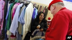 In this 2012 file photo, a shopper looking for clothes at the Salvation Army store in Staten Island, New York, receives a surprise $100 donation.