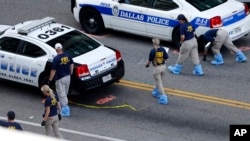 An FBI evidence response team works the crime scene, July 10, 2016, where five Dallas police officers were killed Thursday, in Dallas.