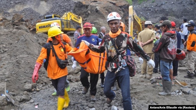 Anggota tim penyelamat membawa jenazah penambang setelah tanah longsor melanda Desa Srumbung di Magelang, 18 Desember 2017. (Foto: Antara/Anis Efizudin via Reuters)