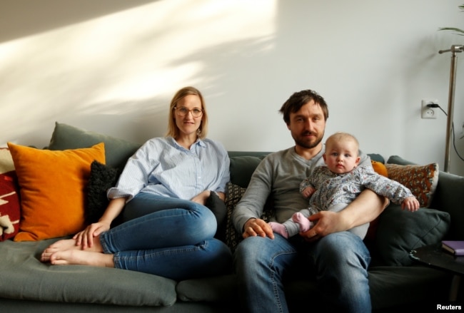 FILE - Lucie Sol, 32, a social worker, her boyfriend, Rudie Jonkmans, 34, a cook, and their 22-week-old baby Lena Amelie pose for a photograph inside their house on the first day Lucie went back to work, in Purmerend, the Netherlands, Feb. 18, 2019.