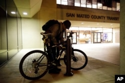 Albert Brown III, who works as a security officer, locks his bike in front of his workplace in San Carlos, California, Oct. 25, 2017.
