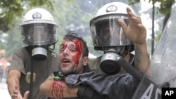 Riot police detain a demonstrator during a protest in Athens' Syntagma (Constitution) square, June 29, 2011.