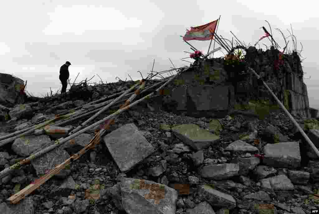 Seorang pria berjalan dekat monumen Savur Mogila yang dibangun untuk mengenang prajurit Red Army yang gugur dalam Piala Dunia II, yang baru-baru ini rusak, dekat kota Snizhnee, Ukraina Timur.