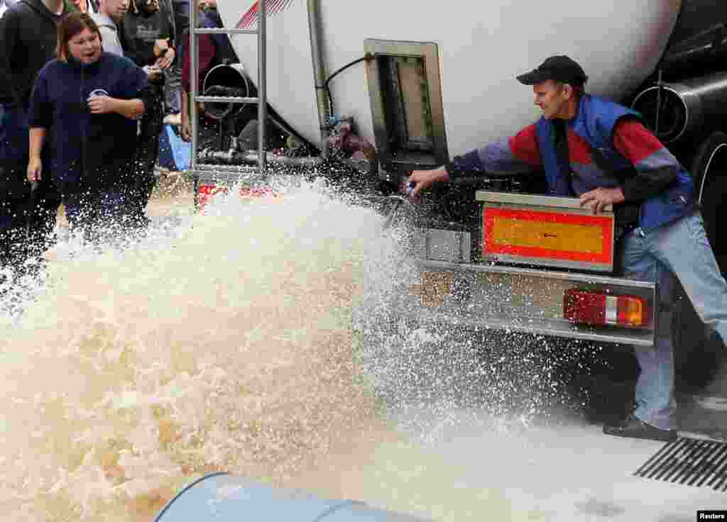A Belgian dairy farmer pours milk from a truck during a protest against low milk prices at the milk processing factory Corman in Bethane near Liege.