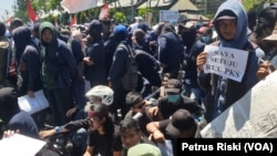 Seorang mahasiswa membawa kertas bertuliskan dukungan pengesahan RUU P-KS pada aksi di depan gedung DPRD Jawa Timur (Foto: VOA/ Petrus Riski).