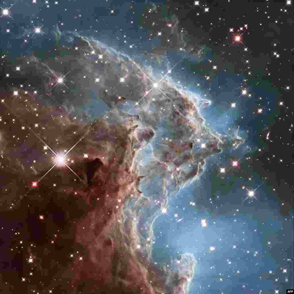 This handout image by the ESA and taken by the NASA/ESA Hubble Space Telescope shows the Monkey Head Nebula or NGC2174, to celebrates its 24th year in orbit. NGC 2174 lies about 6400 light-years away in the constellation of Orion (The Hunter). Hubble prepreviously viewed this part of the sky back in 2011 — the colourful region is filled with young stars embedded within bright wisps of cosmic gas and dust. This portion of the Monkey Head Nebula was imaged in the infrared using Hubble's Wide Field Camera 3.