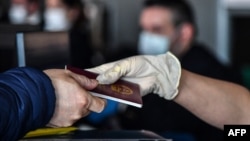 一名乘客递交他的中国护照（2020年1月23日）