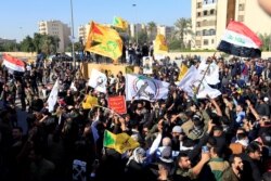 Las Fuerzas de Movilización Popular respaldadas por Irán se reúnen fuera de la Zona Verde fuertemente fortificada, la sede del gobierno de Iraq y la embajada de Estados Unidos, en Bagdad, Iraq, el 31 de diciembre de 2019.